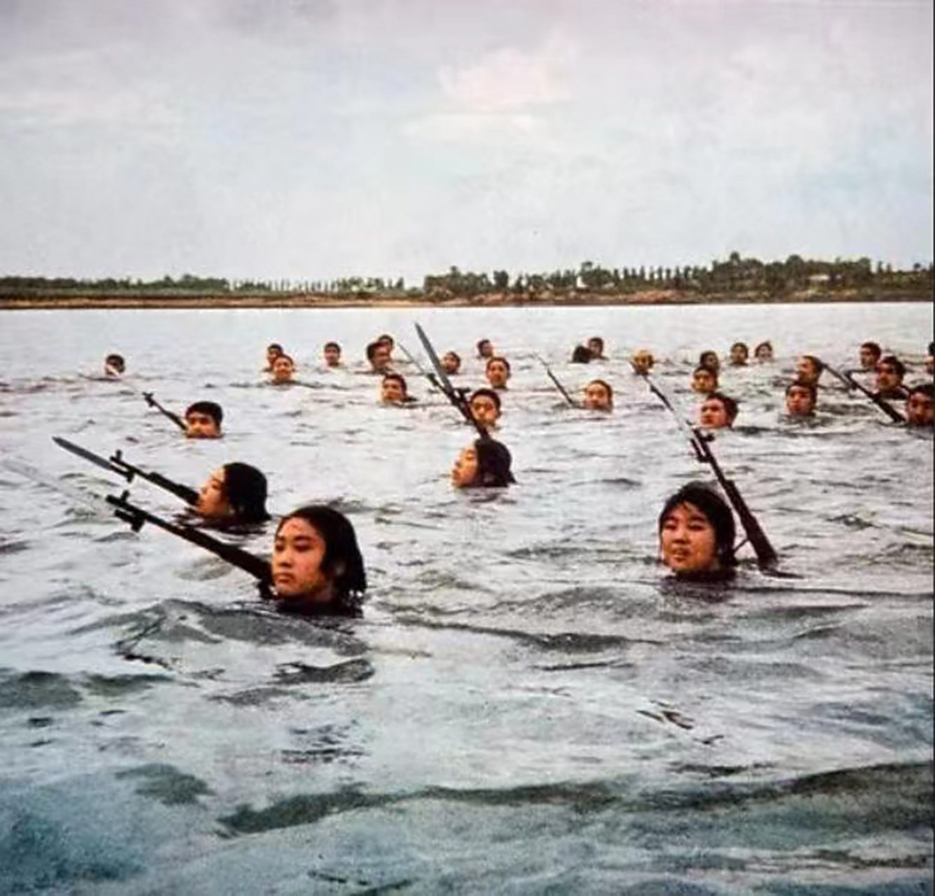 这张历史老照片展现了一个时代的风貌,年轻人们在河里游泳时,身上带着