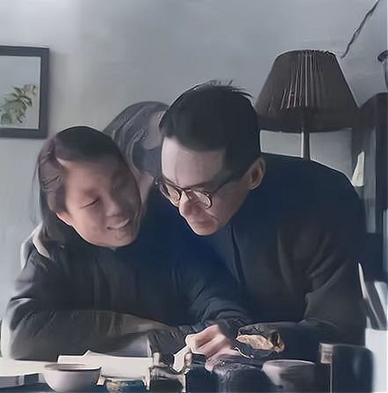 照片中的梁思成坐在书桌前,正与林洙交谈,而林徽因已经逝去了七年.