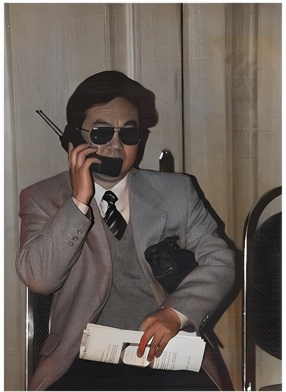 90年代的广州,一位用"大哥大"打电话的老板,画面中,他拿着显眼的"大