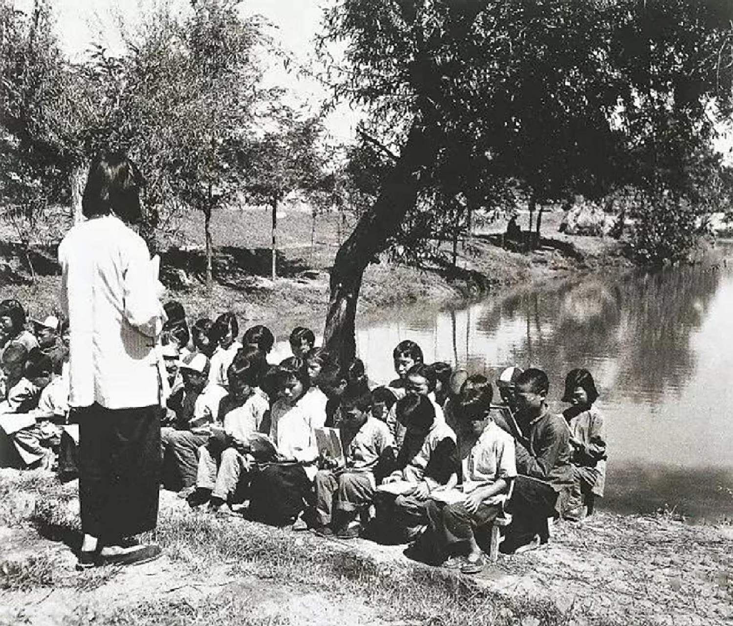 20世纪40年代,山东某地的小学生在老师的组织下在水塘边上课.