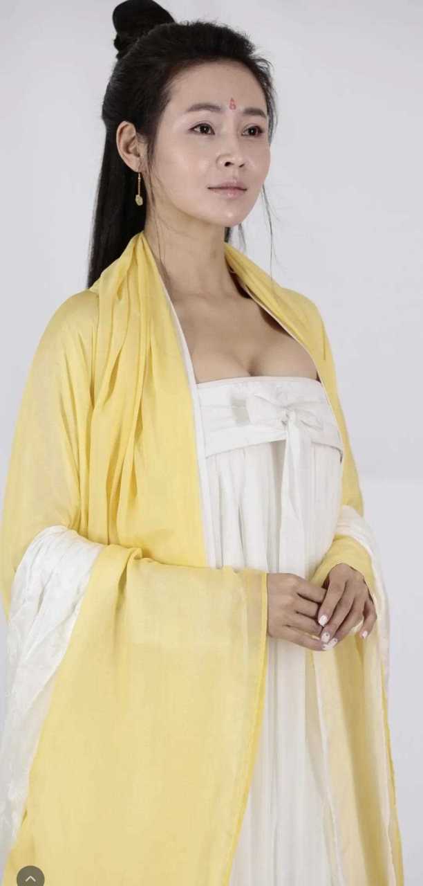 于明加古装剧集定妆照,杏黄色的长裙,白色的抹胸,看着像唐朝的风格