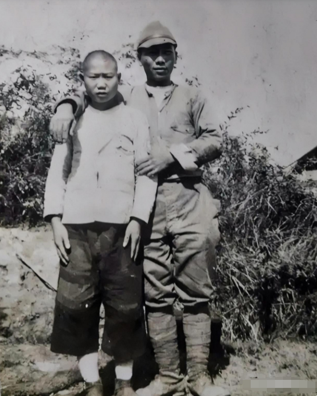 照片中一个日本鬼子亲昵的揽着一个中国少年,看上去颇有其宣传的那般