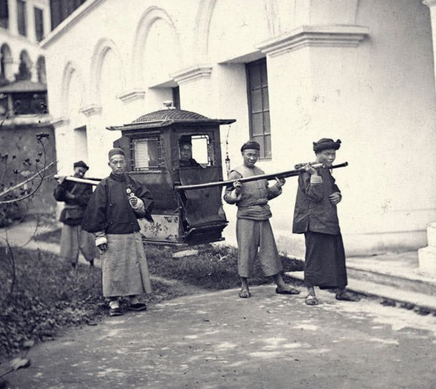 在一张照片中,我们可以看到三个轿夫在抬一位大腹便便的官老爷子,而