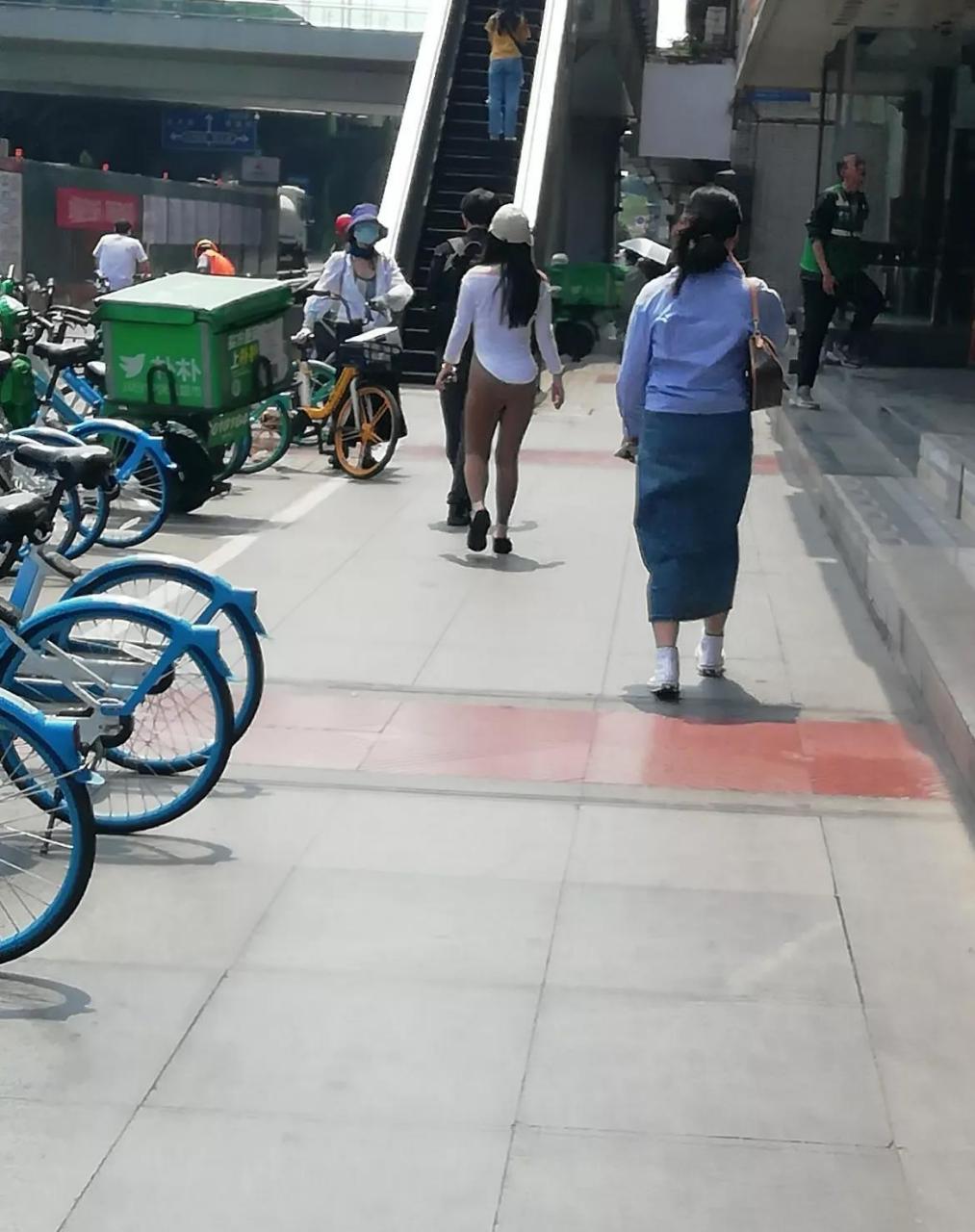 一位女士穿着很薄的紧身裤从旁边走过,都勒出了一条缝,回头率杆杠的