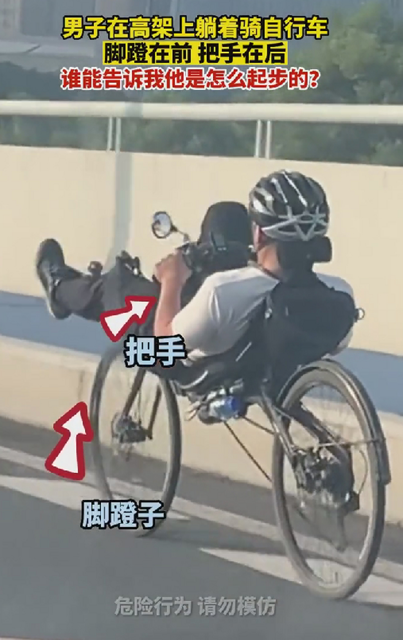 男子在高架上躺着骑自行车