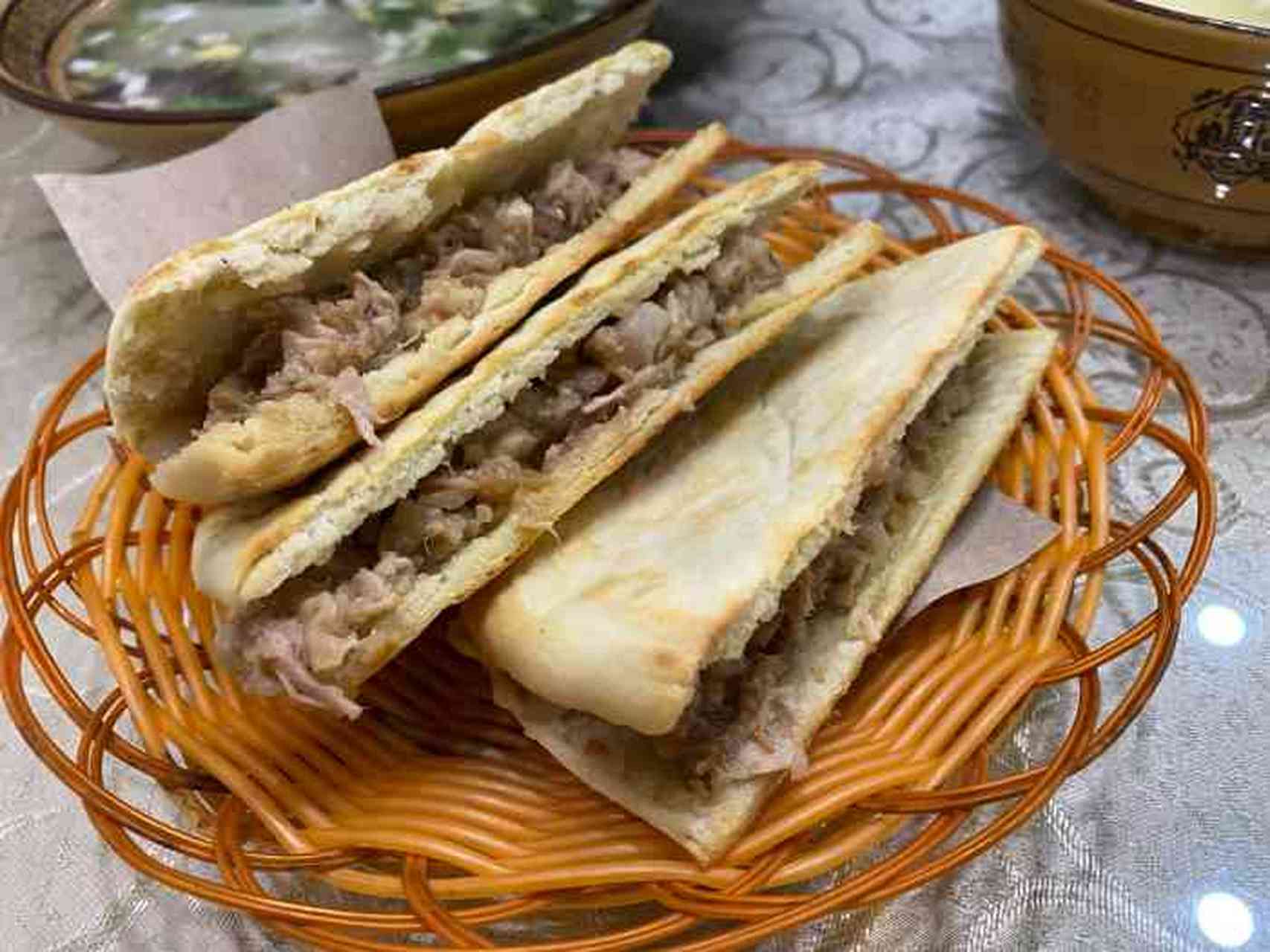 锅盔牙子选上等麦面粉和死面(不经发酵),揉压成马蹄状(形似荷叶饼,厚