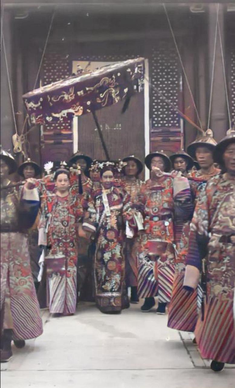 1903年,慈禧太后在一群太监的簇拥下前往颐和园的仁寿殿,身边两大太监