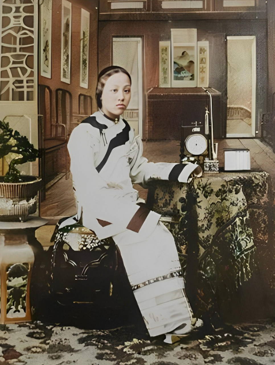 这是一名清末时期的满族女子,虽然上身穿着当时汉族妇女的衣服,但她的