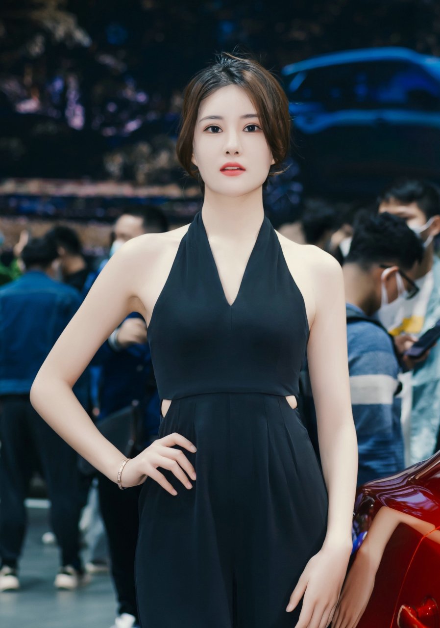 在车展上,那位漂亮的车模吸引了众人的目光.