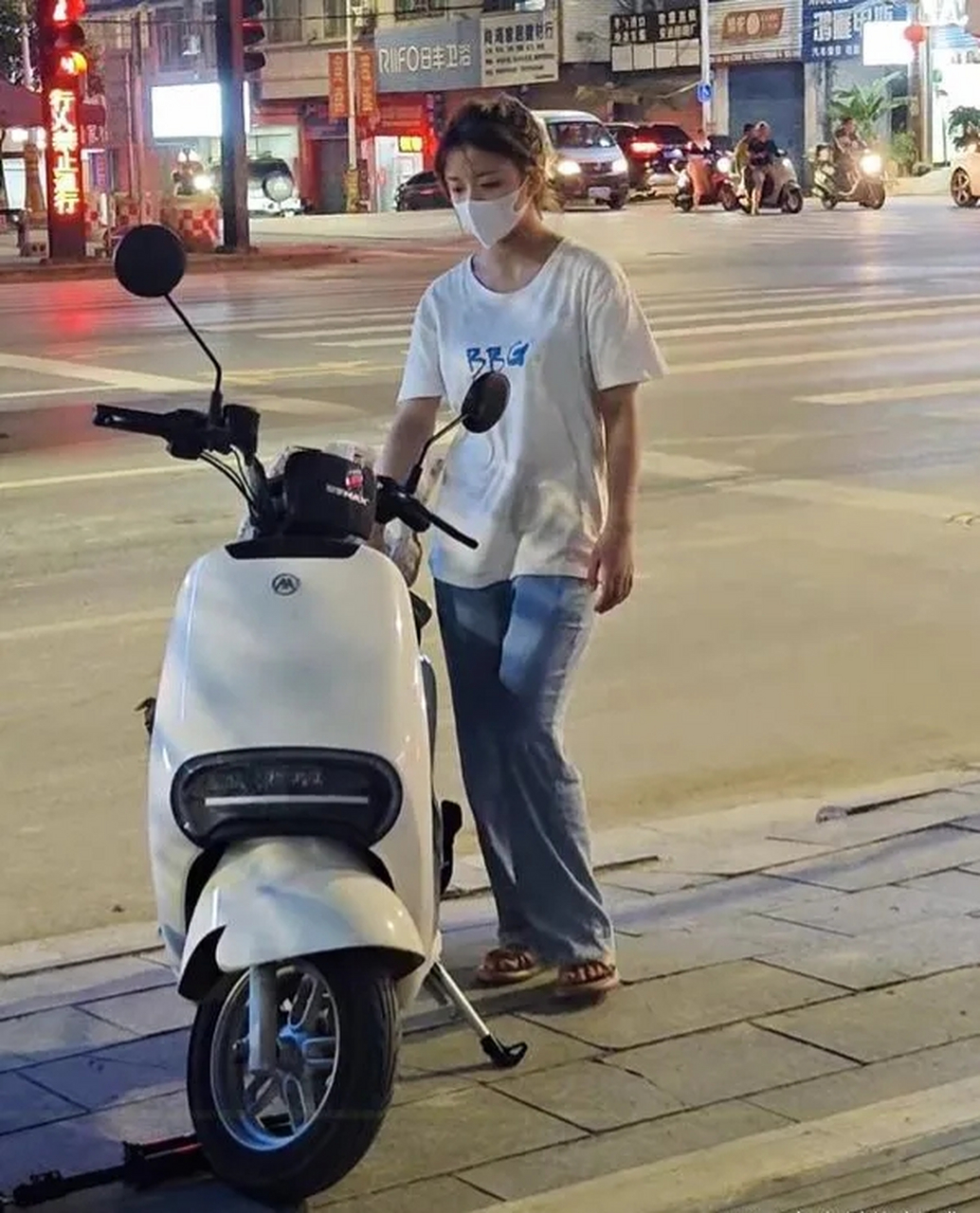 广西街头,这个神情落寞的小姑娘吴雨静,和自己新买的电动车自拍,却