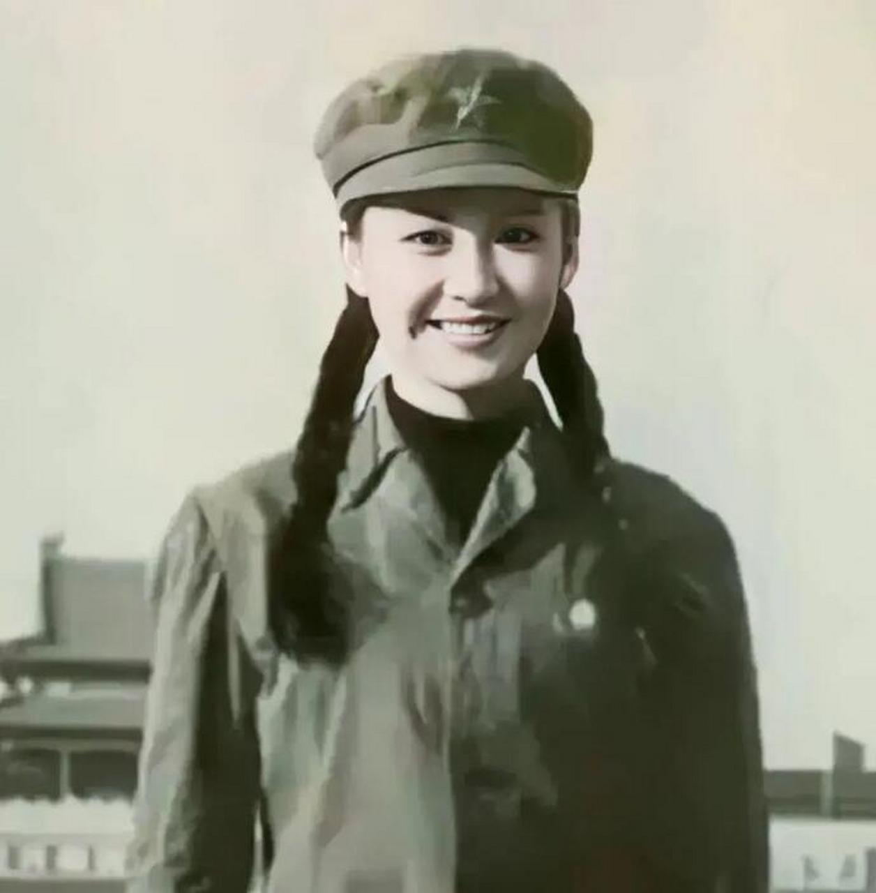 1988年,19岁的许晴身穿军装,佩戴军帽,两个麻花辫子穿过头顶,笑脸迎向