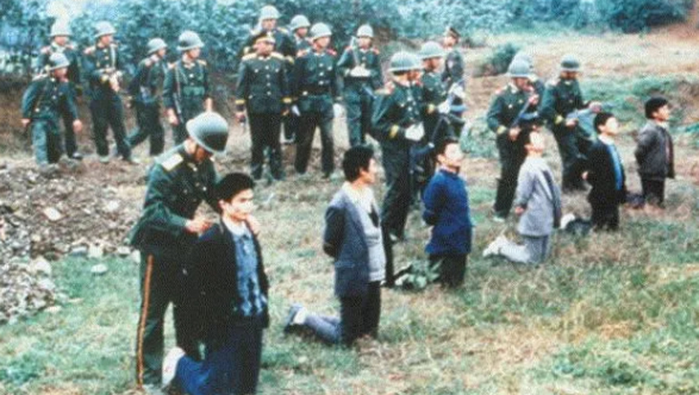 80年代,郊外刑场,几名等着被处决的犯人,镜头中这些犯人依次排开,跪在