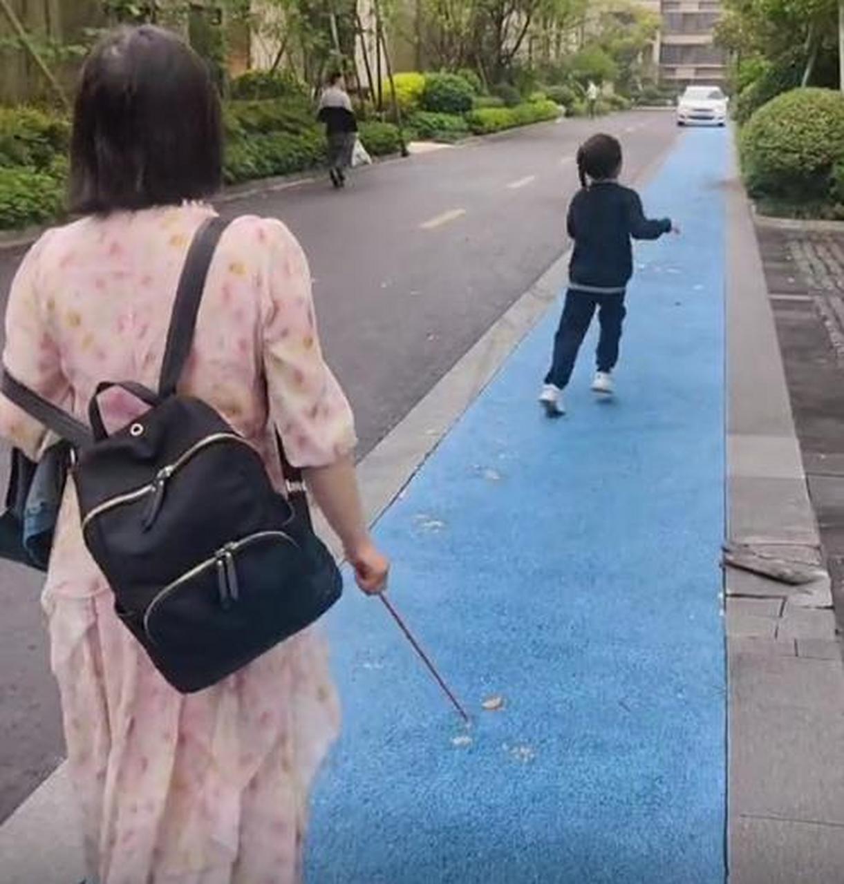 女儿不想上学,妈妈拿了跟棍子在后面追着打,女儿一边跑一边哭,爸爸