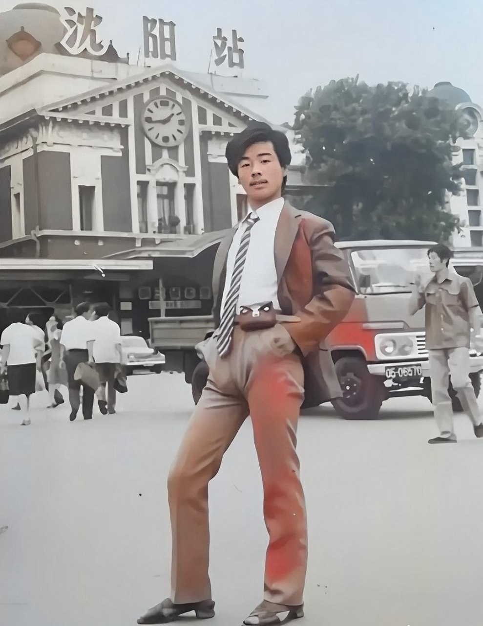 他自信地穿着时髦的西装,高跟凉鞋,腰间挂着一个传呼机