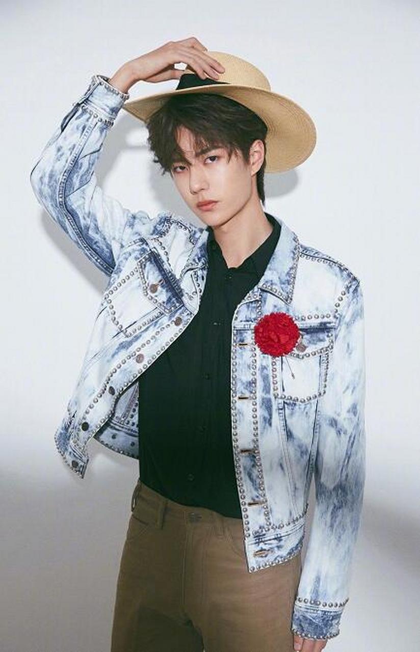 王一博身穿铆钉水洗牛仔衣配黑色衬衫,胸口的别致大红花让整体造型从