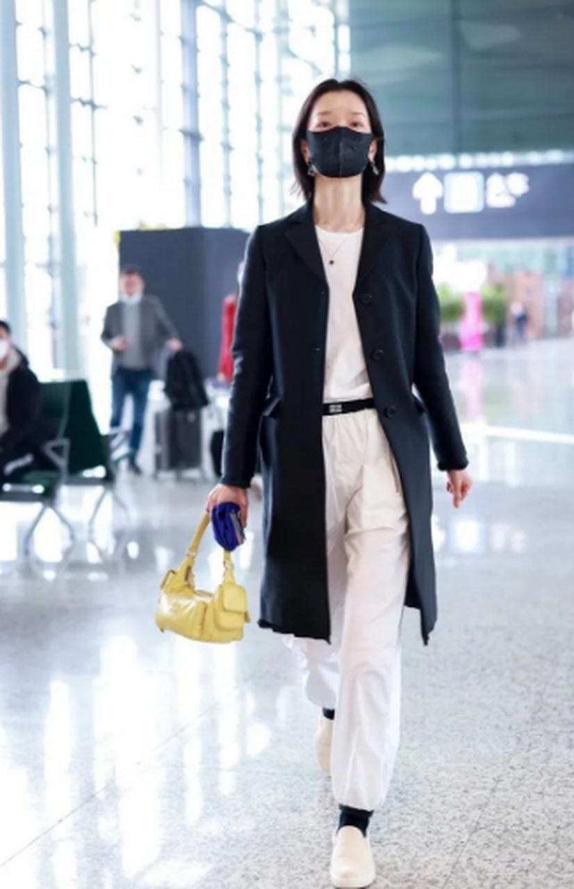超模杜鹃出现在上海机场,穿黑色的风衣配白色裤子,格外洒脱,看上去很