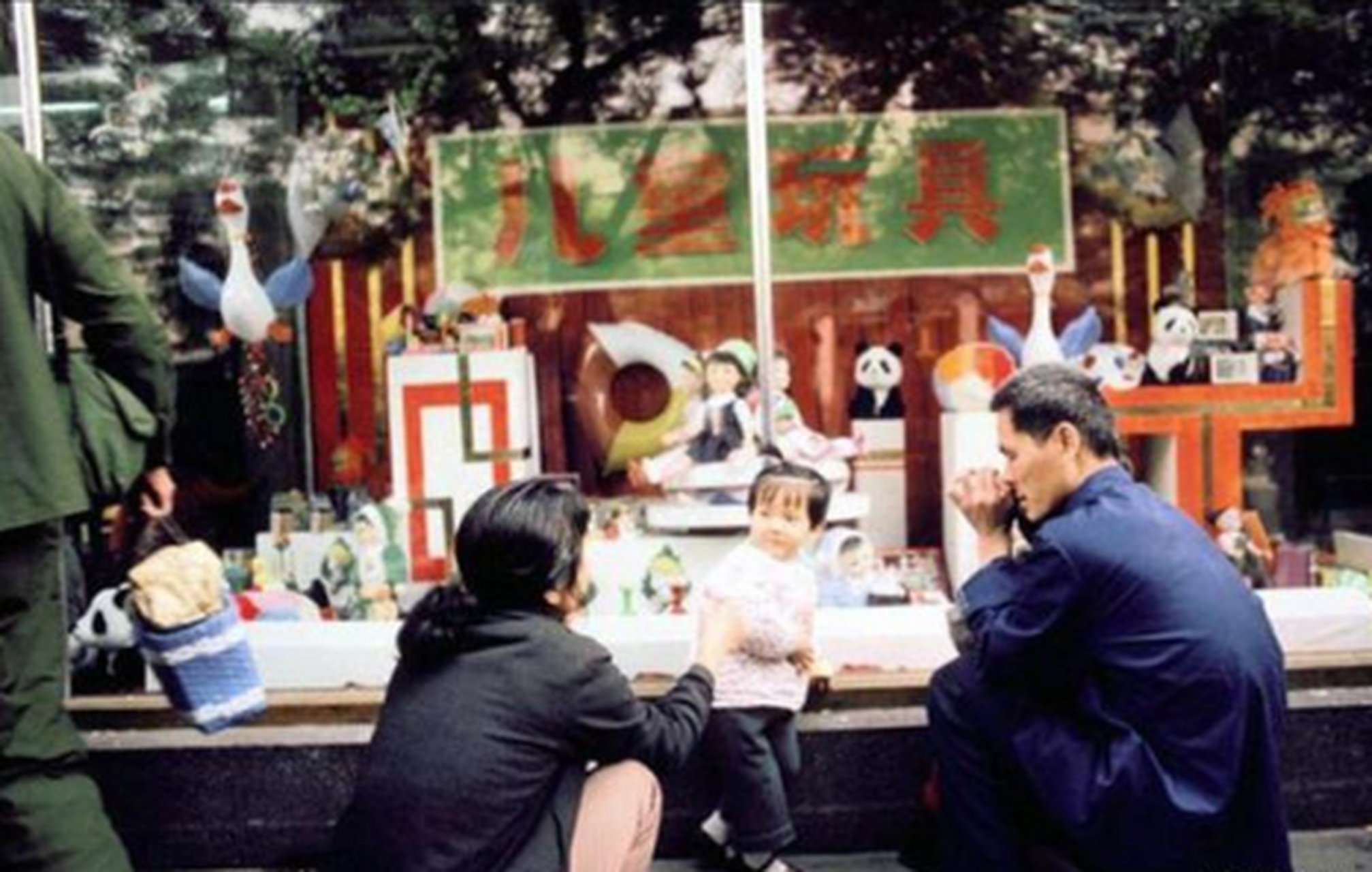 1985年,北京一個商場的兒童玩具櫥窗外,一對夫婦帶著孩子在挑選玩具