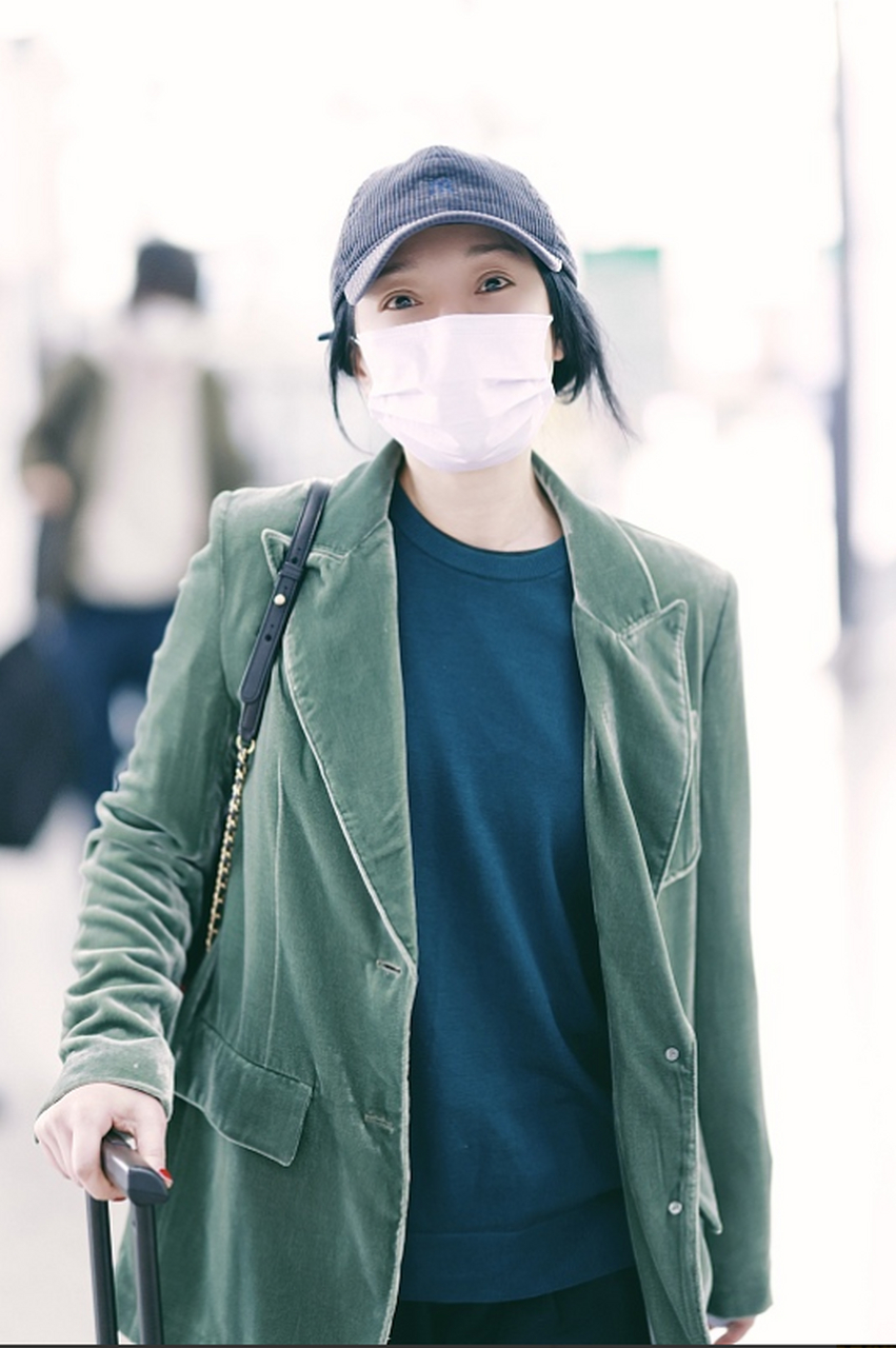 周迅最新机场照,她戴了一顶藏蓝色的棒球帽,穿一件军绿色的灯芯绒休闲