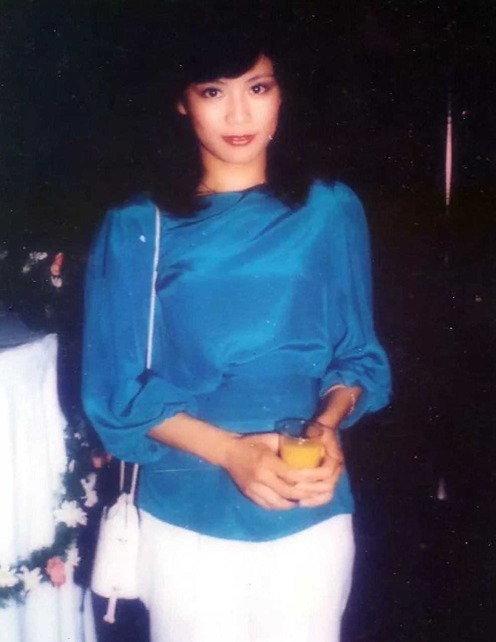 翁美玲和陈百强的合影.蓝衣白裤的阿翁对着镜头微微一笑,端庄美丽.