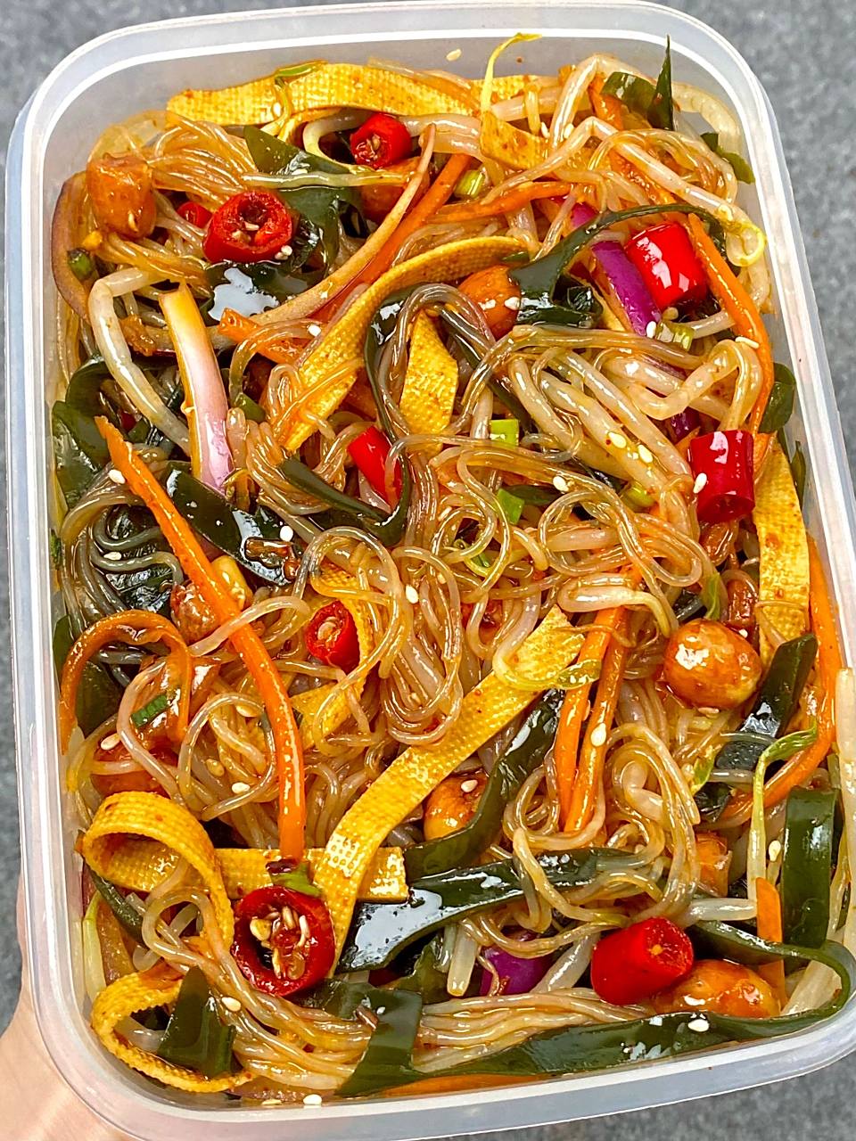 在小区门口的路边摊,有一位阿婆出售的凉拌海带粉丝拌豆皮吸引了无