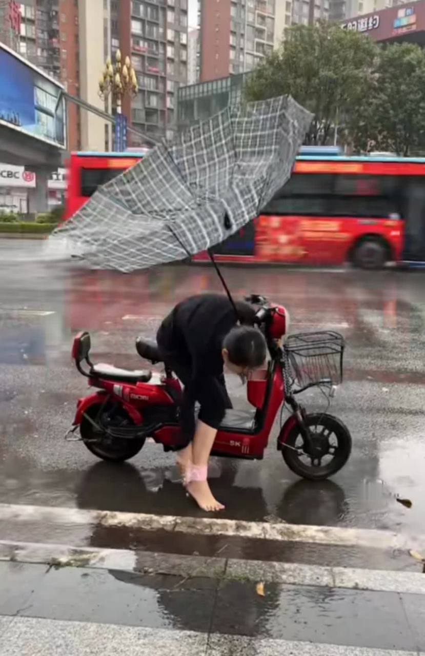 这风也太大了,雨伞都被吹翻了,这位大姐顾了下面,顾不了上面.