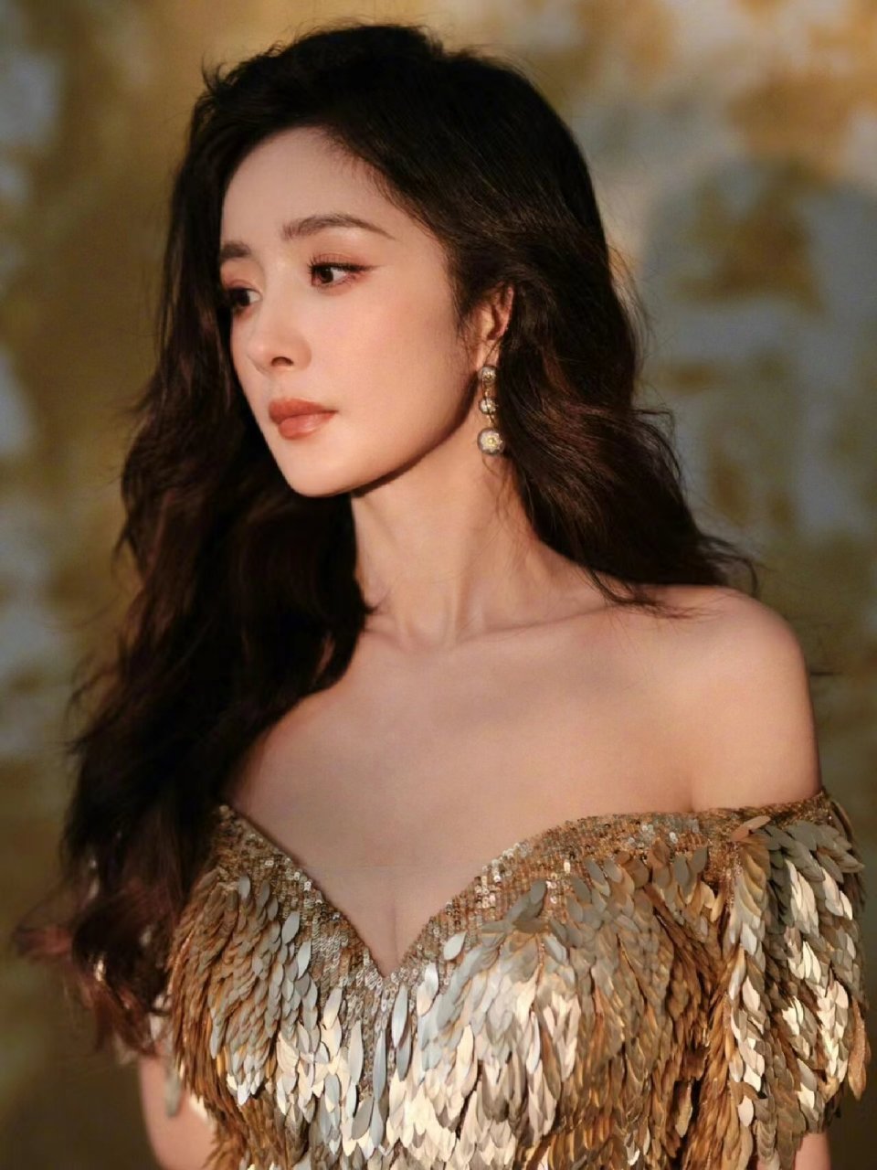 杨幂身穿鎏金羽翼裙亮相,金色亮片刺绣散落在裙身上,显得隆重又耀眼