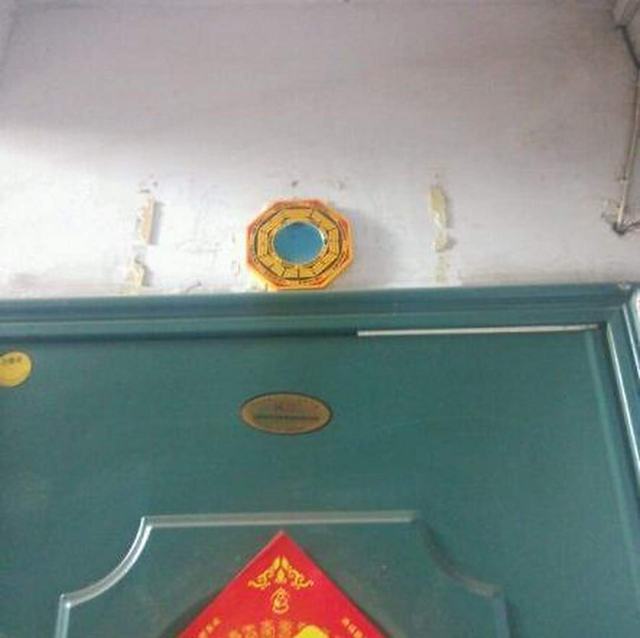 回家的时候,发现邻居门上,挂着一个八卦镜,就正对我家大门.