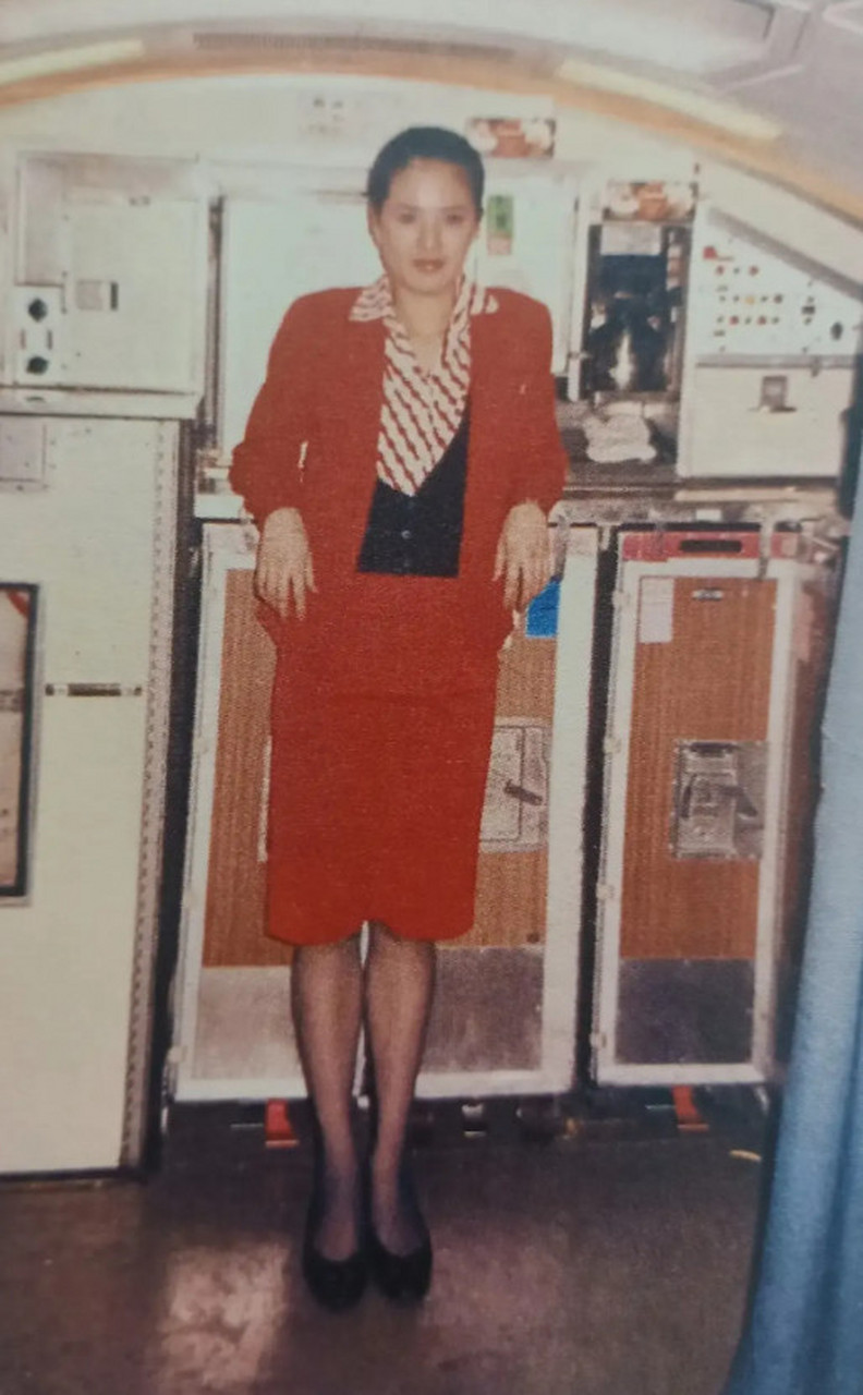 1988年,香港国泰航空客机,22岁的女空姐李若彤一身红色制服,身材高挑