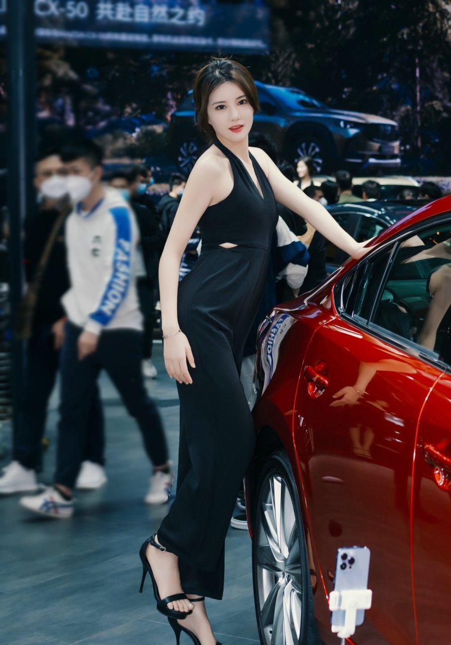 在车展上,那位漂亮的车模吸引了众人的目光.