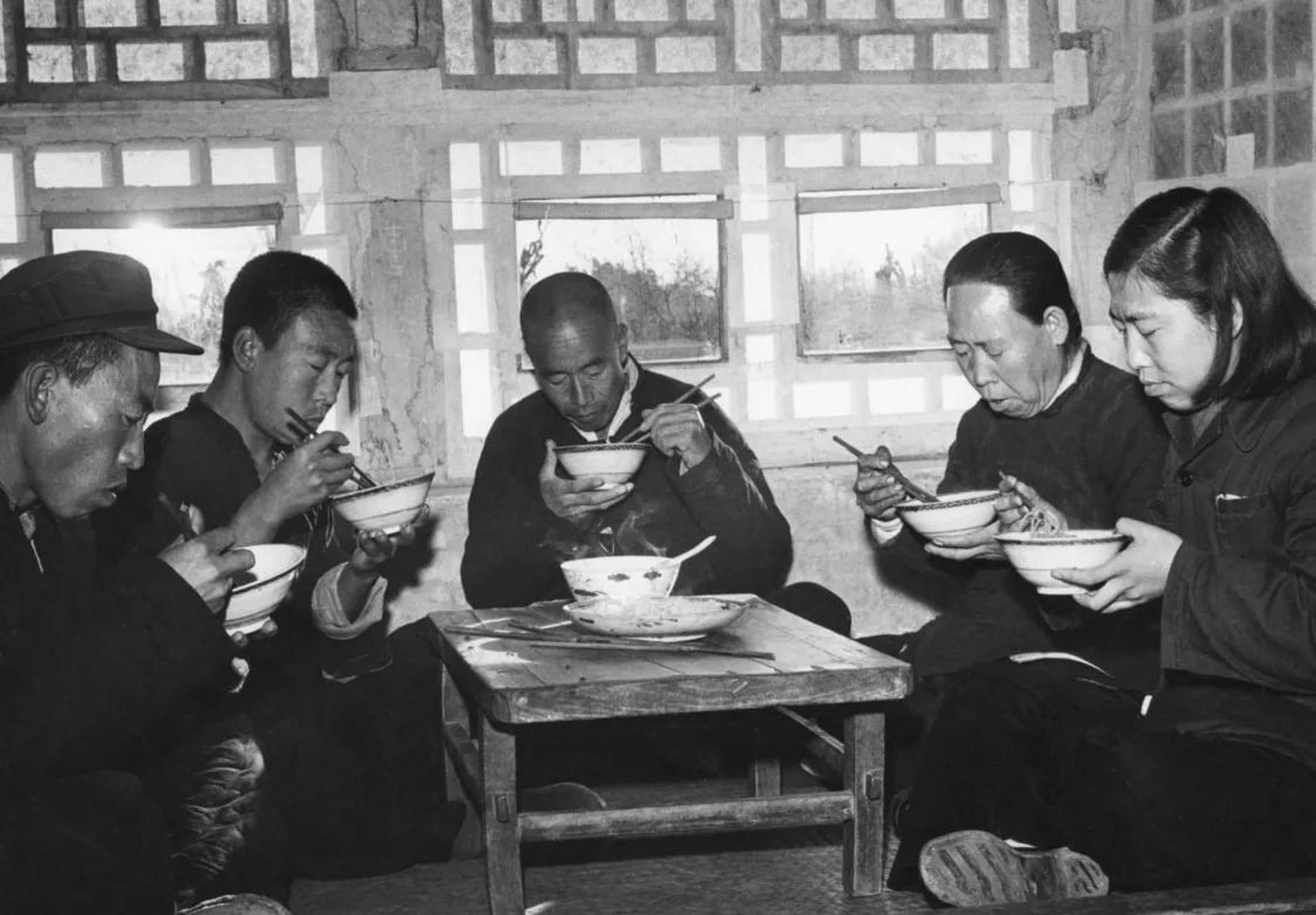 老照片:1955年,北京近郊的农民家庭,他们盘腿坐在炕上吃饭