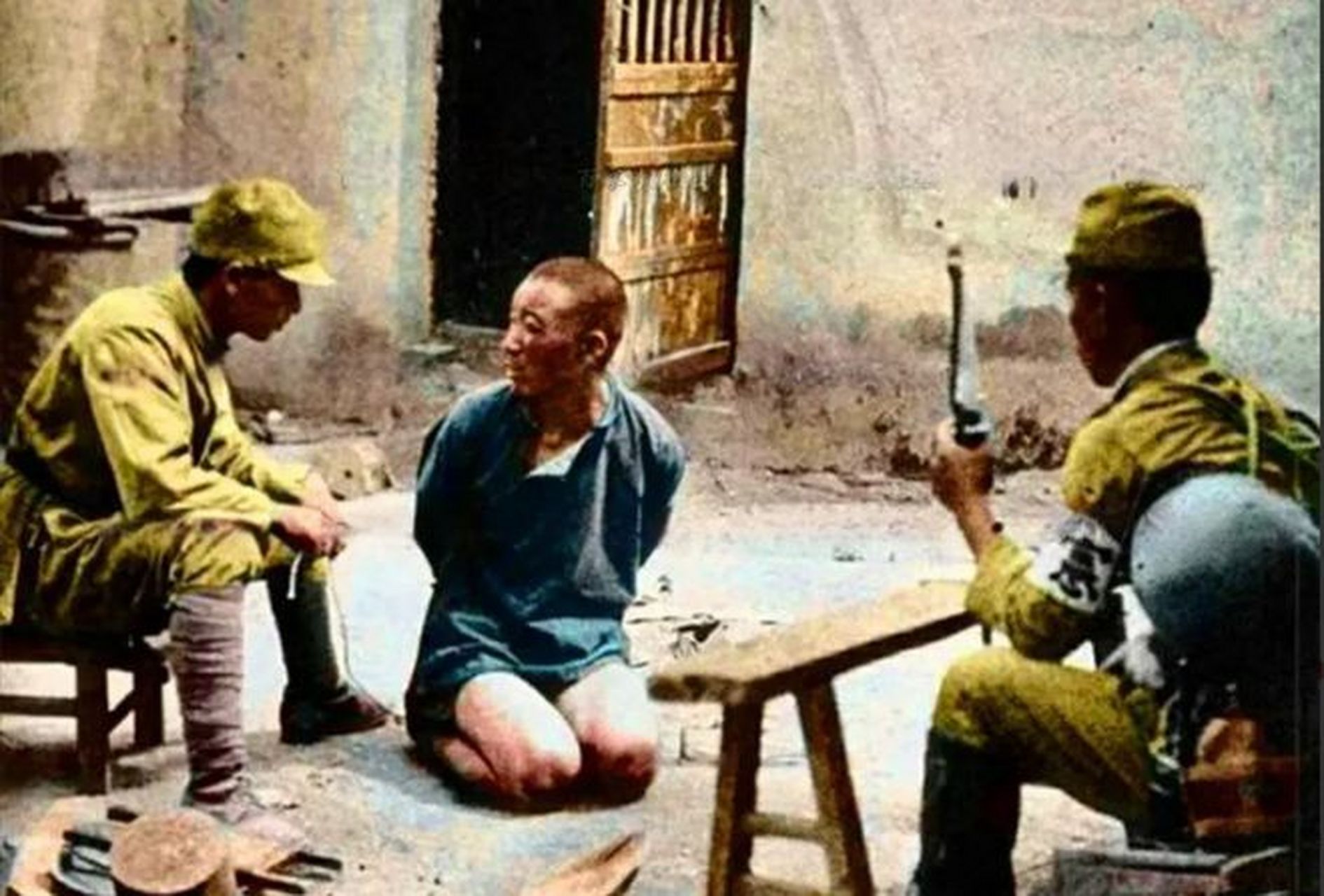 1938年,山西闻喜县的一个村庄中,两个日军反着捆绑着一个农民,让他