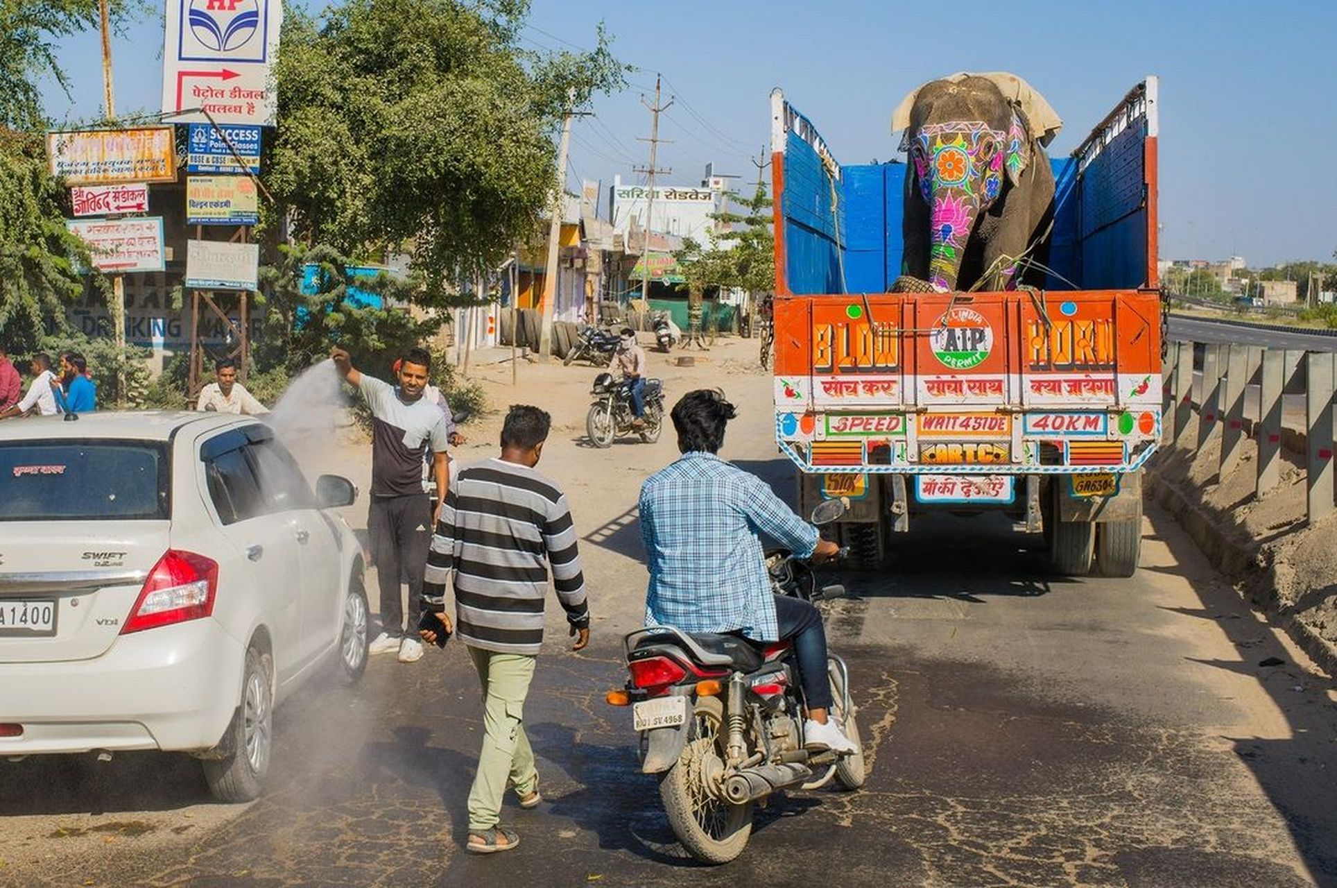这是在印度的路上,一辆大卡车正载着一只训练不久的大象前往婚礼表演