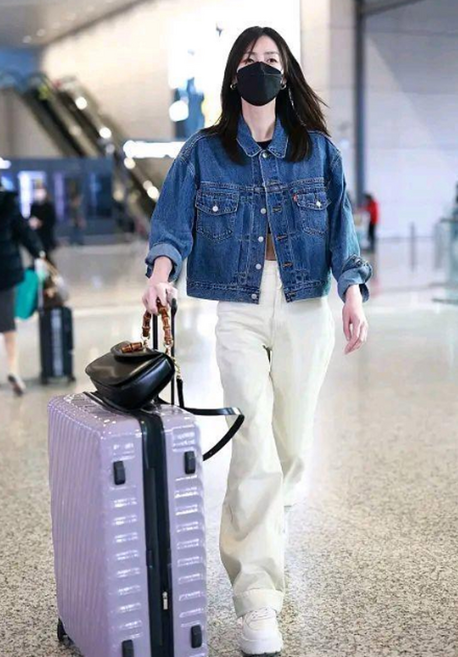 刘雯最新街拍,她穿一件蓝色的牛仔短外套,搭配了一条白色的高腰长裤