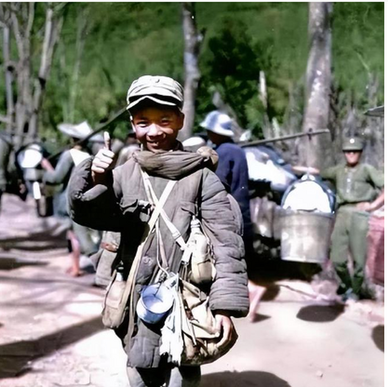 这张娃娃兵穿着远征军的棉服,脖子上挂着一个干粮袋,肩上有大水壶和