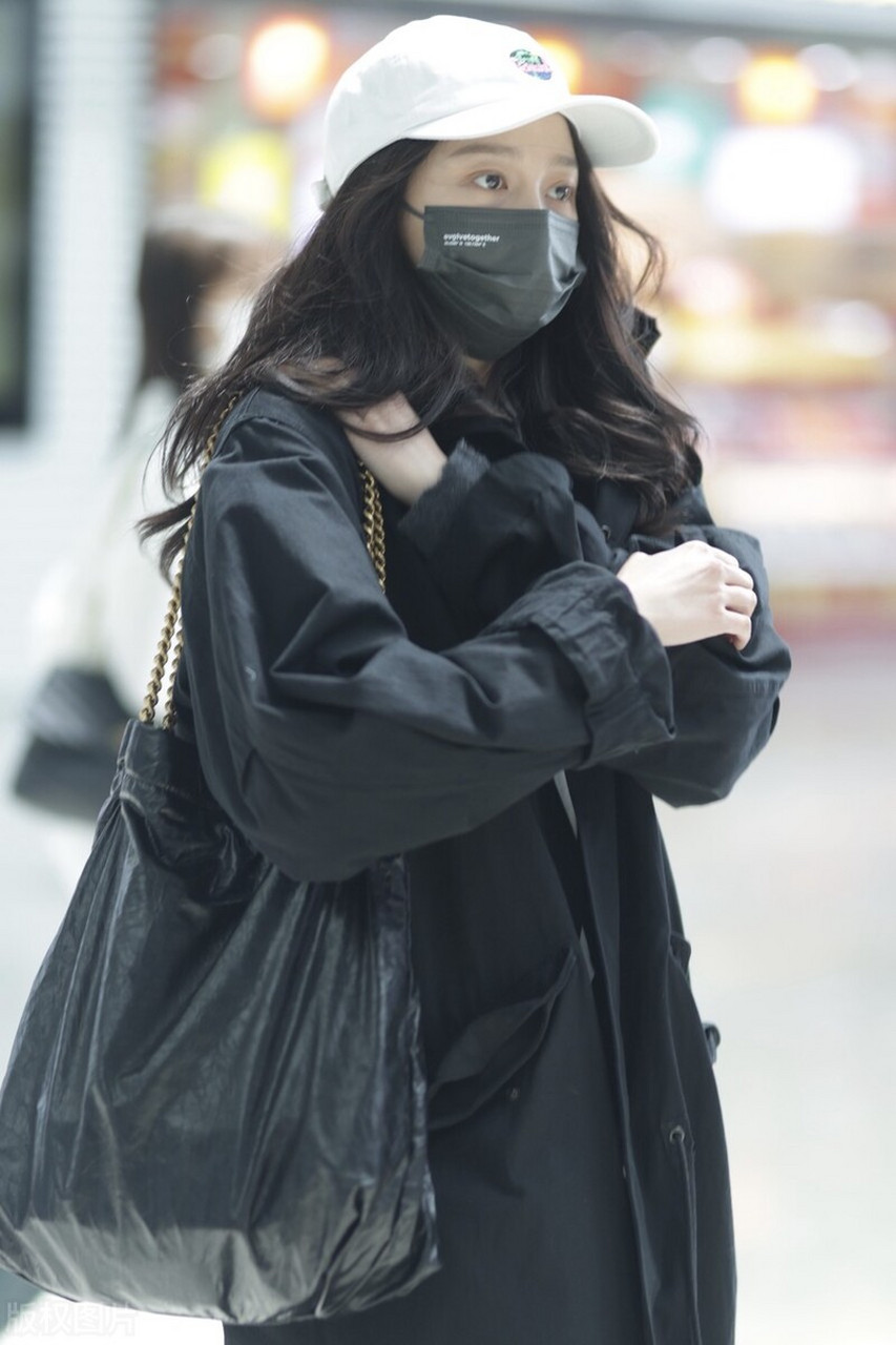 关晓彤机场街拍,黑色风衣搭配黑色阔腿裤,头戴白色棒球帽潇洒大方!