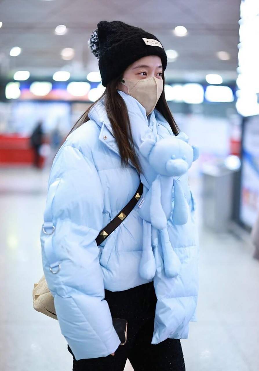 张雪迎机场街拍 蓝色羽绒服 毛线帽 valentino手袋休闲可爱