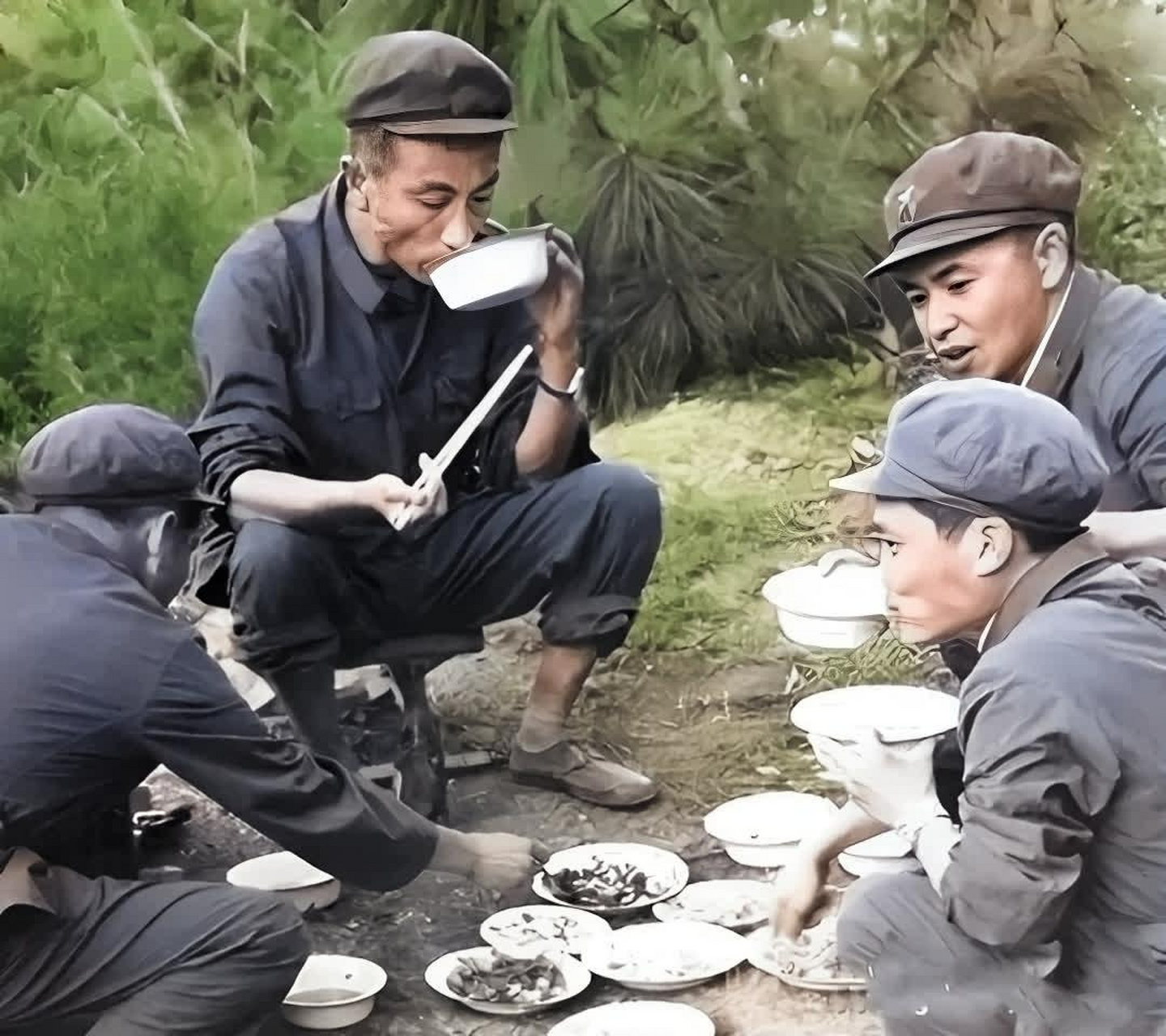 70年代几位解放军战士,吃饭的场景,图中有的坐在马扎上,有6767的