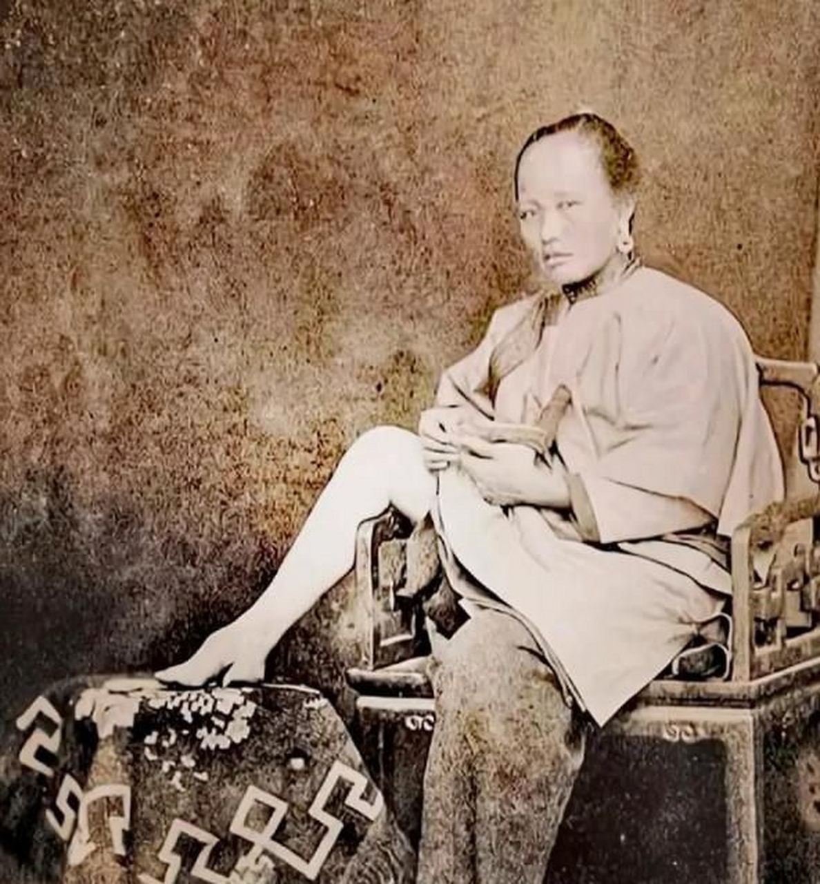 清朝末年.一个女子在展示她的三寸金莲,当时的社会以欣赏小脚为美.