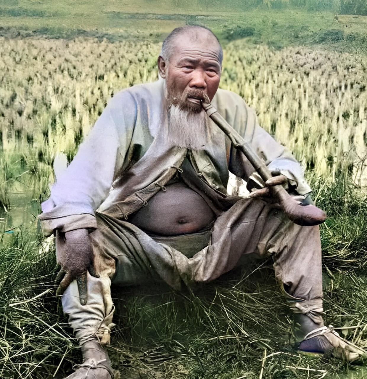 1925年,广州的一位农民伯伯与妻子,女儿在稻田边休息