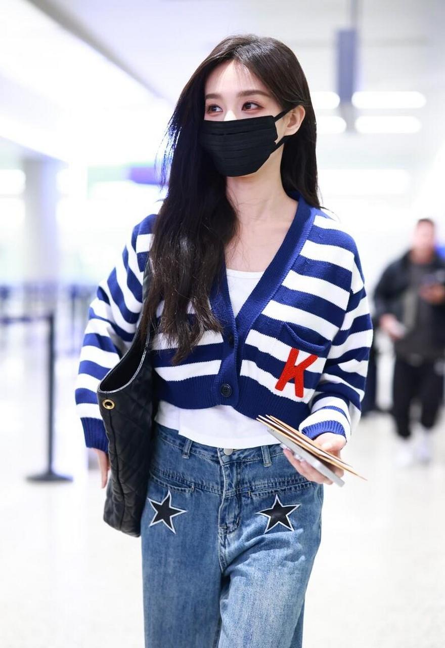 李一桐机场街拍,身穿条纹开衫搭配牛仔阔腿裤,圣罗兰手袋休闲时尚 您