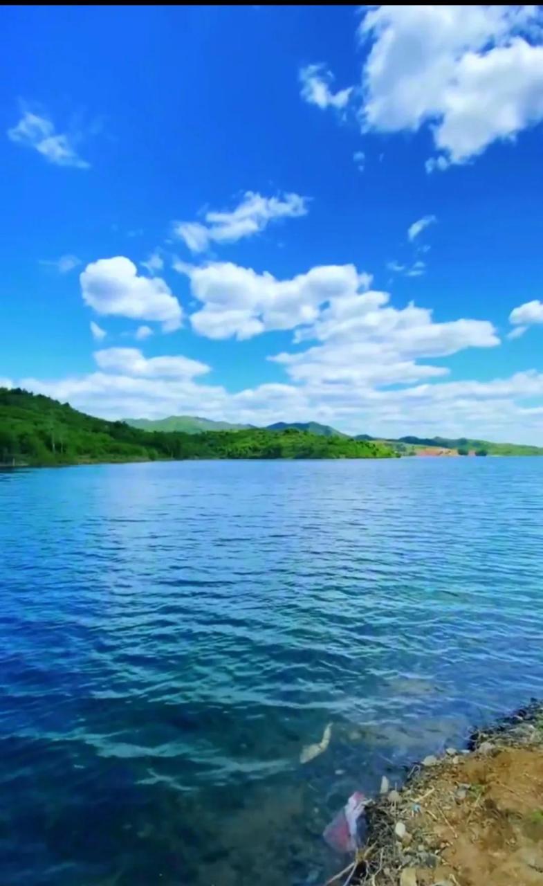 蓝蓝天空, 白白的云下, 大山披满了绿装, 静静的河水清澈见底.