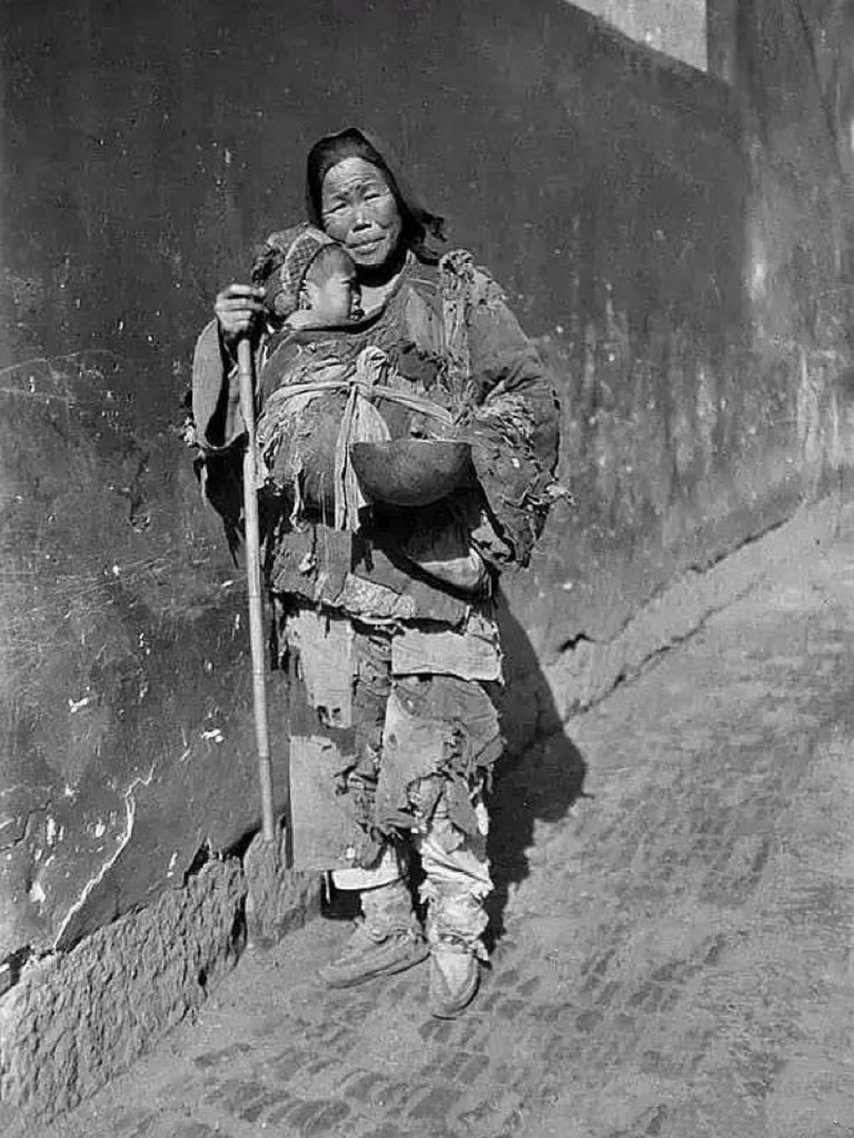 晚清时期,一对乞丐母子的艰难处境照片,画面中的母亲为了保护孩子