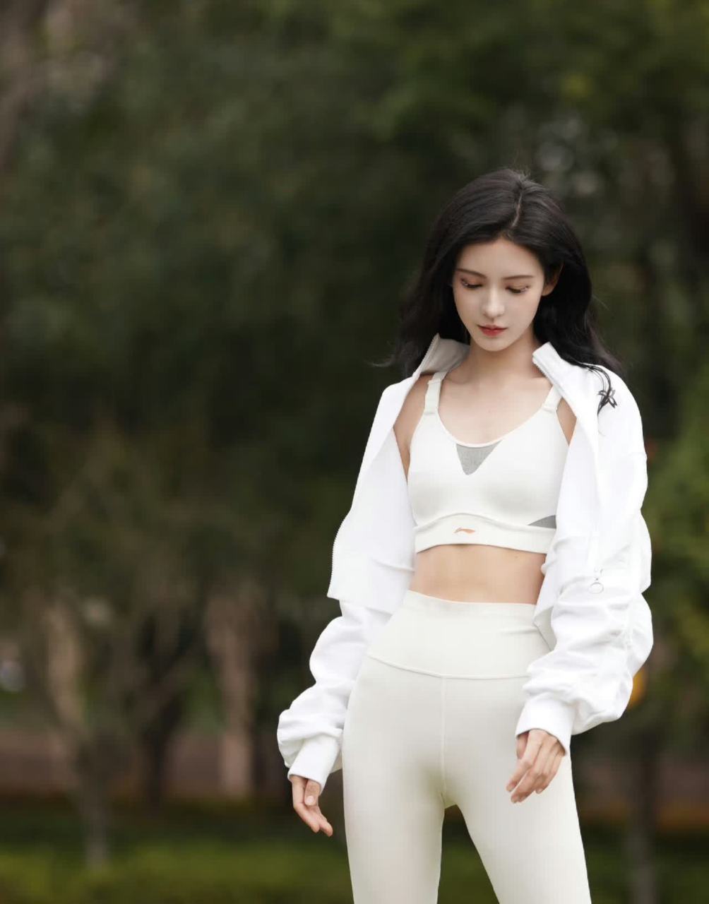 张予曦光着脚坐在草地上,练习瑜伽.