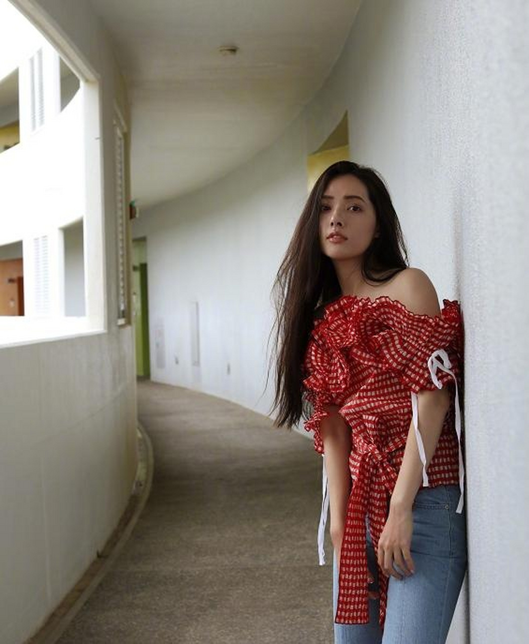 郭碧婷搭配了一条蓝色的牛仔裤,在长廊上跑来跑去,当她转过头的那一