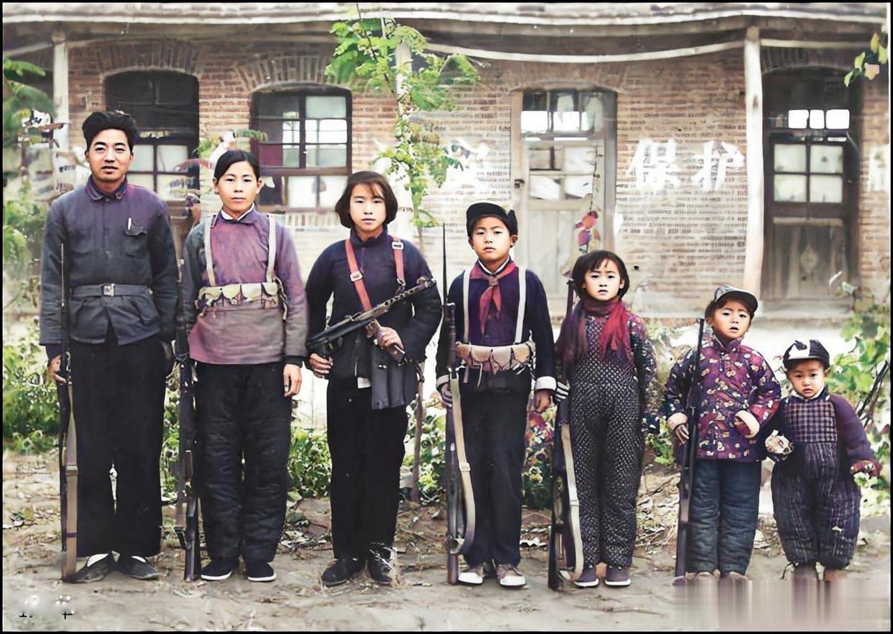 60年代,一个民兵家庭的合影照片,画面中的母子孩子都是全副武装,看着
