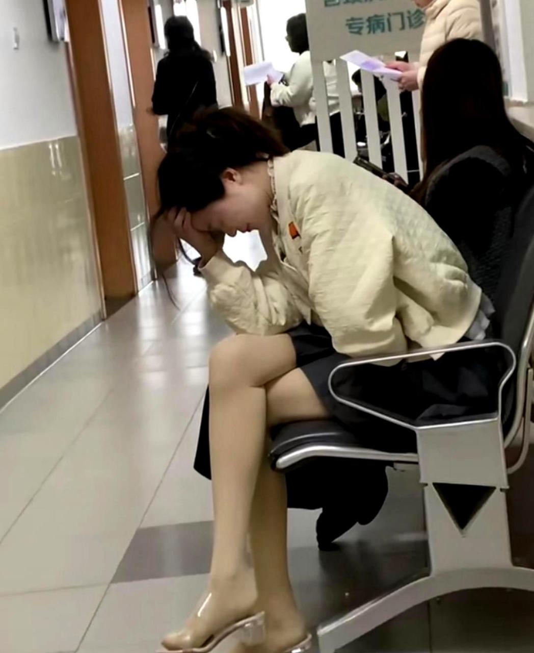一个女子独自蜷缩在医院里看病,让人不禁感到心疼.