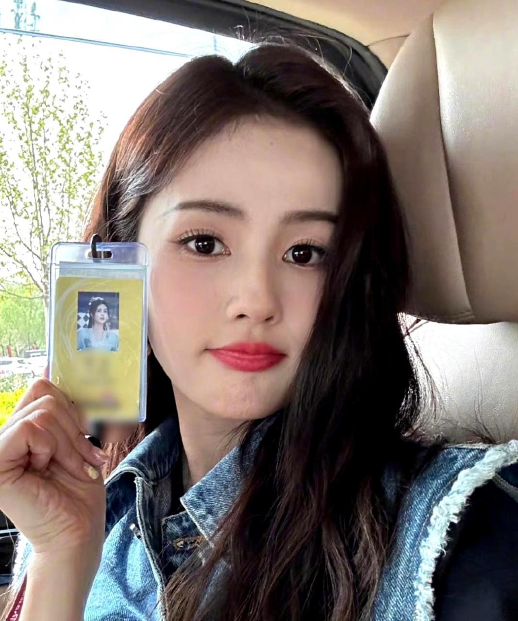 白鹿拿着工牌在座位上自拍,表情呆萌可爱.