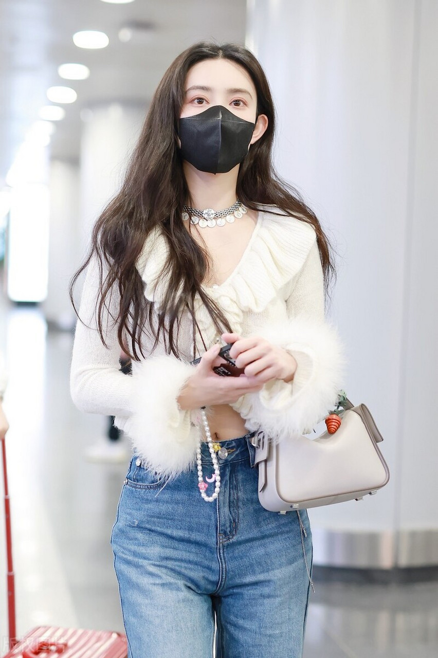 孟子义机场街拍,白色荷叶边针织衫搭配阔腿牛仔裤,白色运动鞋时髦复古