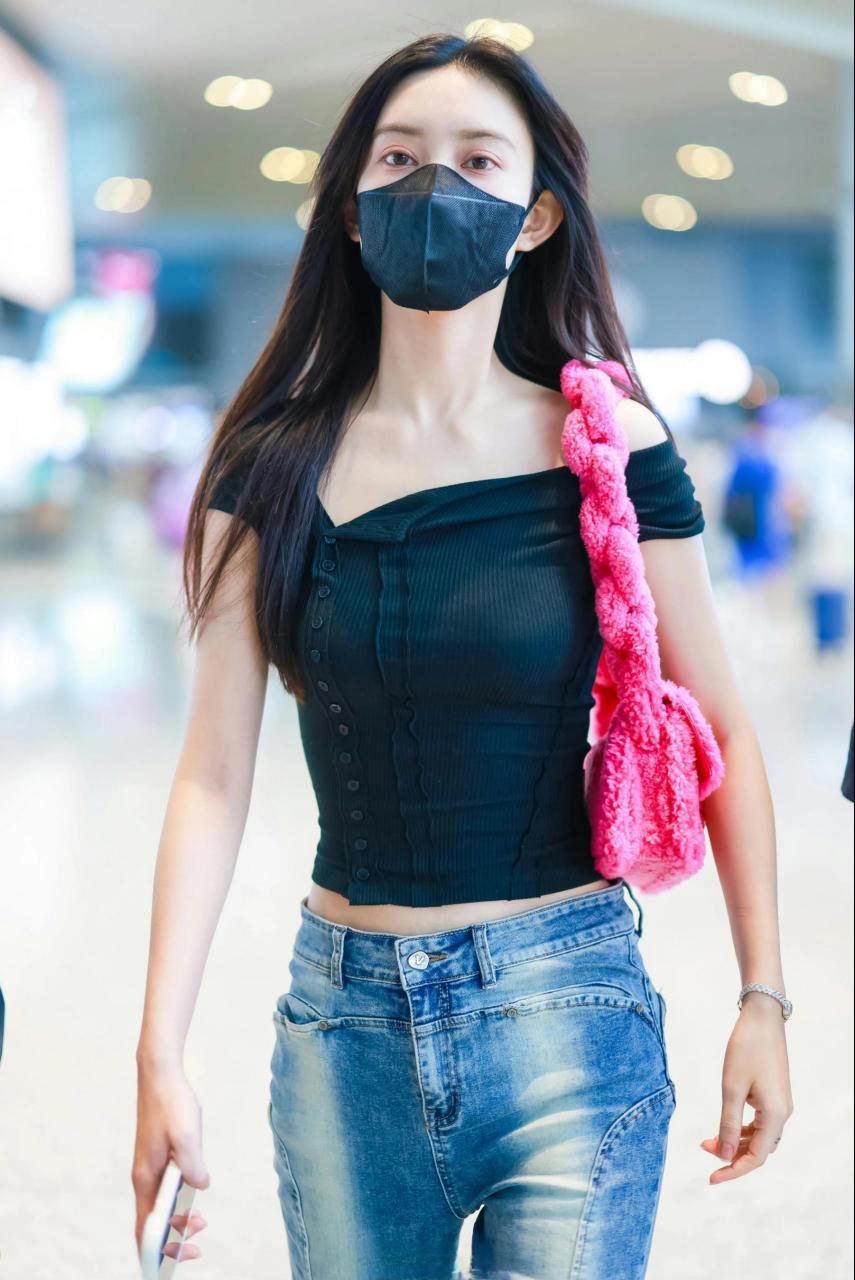 孟子义机场look,黑色修身露肚上衣搭配微辣牛仔裤,粉红色的皮毛包包