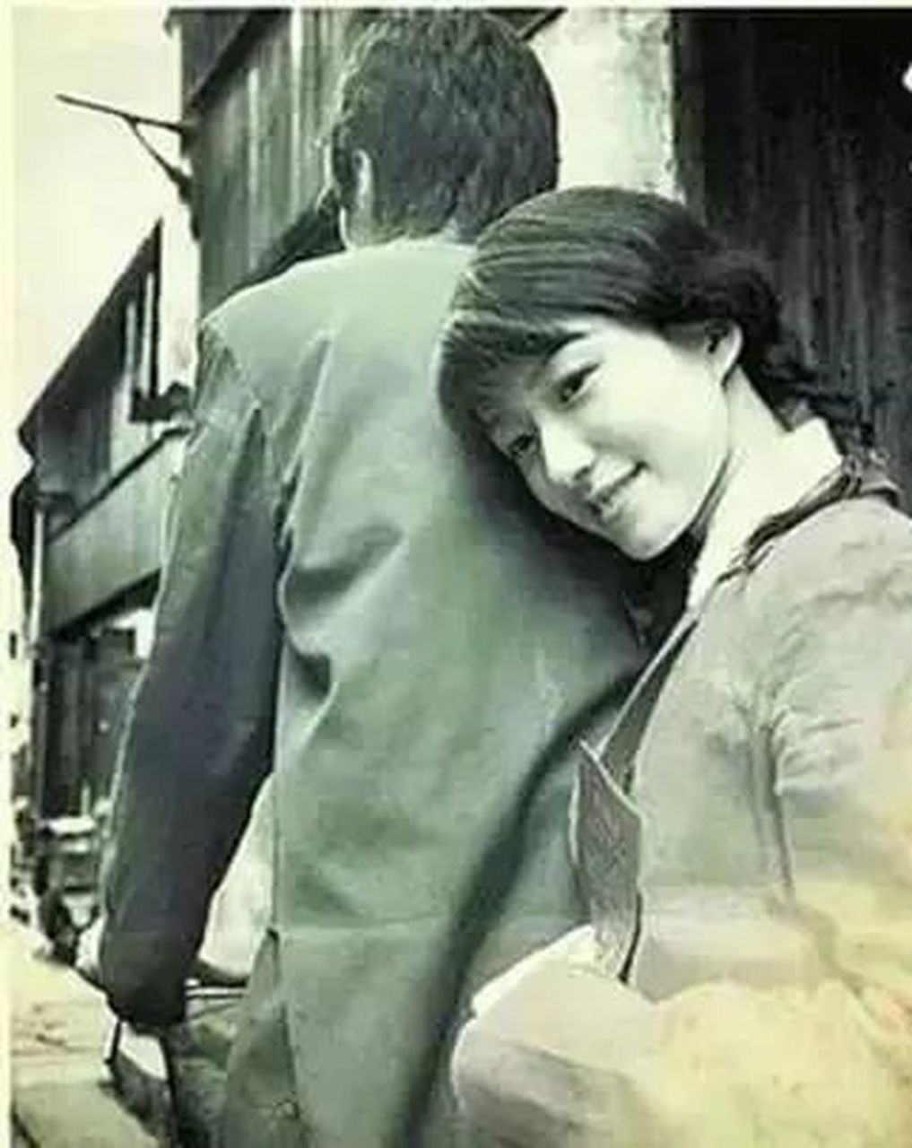 女孩坐在男友自行车后座上,头依在男友的后背上,脸上洋溢着幸福的微笑